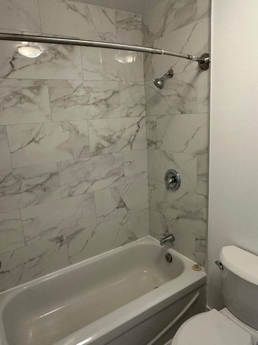 Calacatta marble-look shower surround with new chrome fixtures