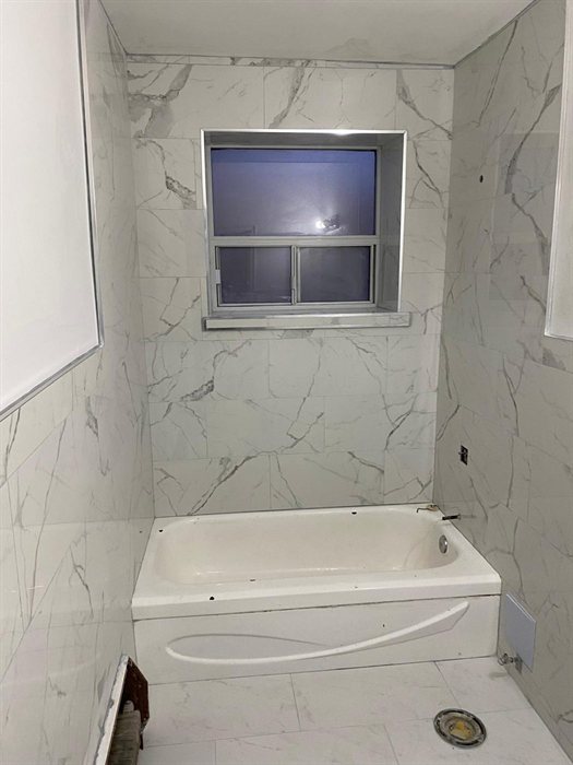 Full-height marble-look tile with tiled window return