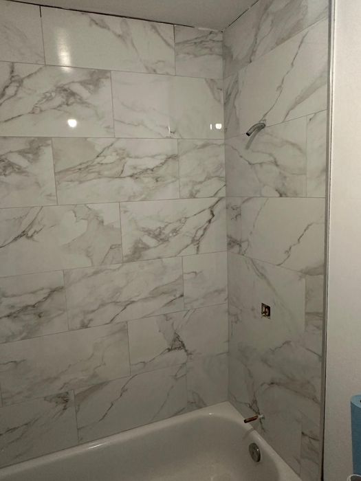 Large-format marble-look tile around the tub